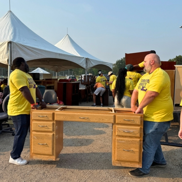 Volunteers moving a desk