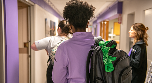 A student in Lafene Health Center with a green bandana on her backpack