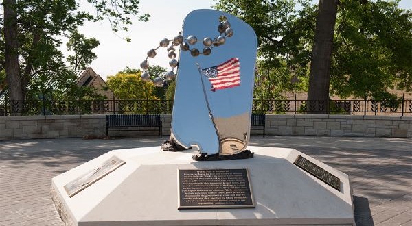 Veteran's memorial statues of a mirrored dogtag on mounted concrete