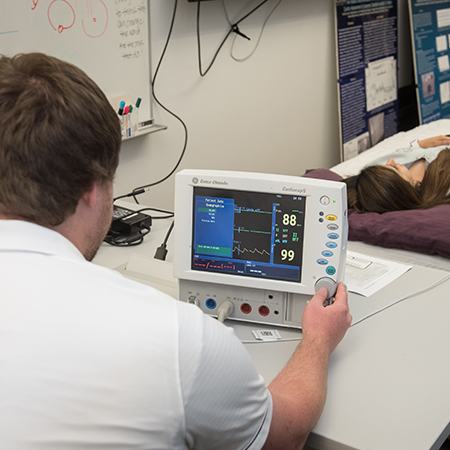 Student monitors vitals on a screen.