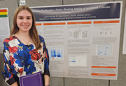 Laura Bishop standing next to her research poster.