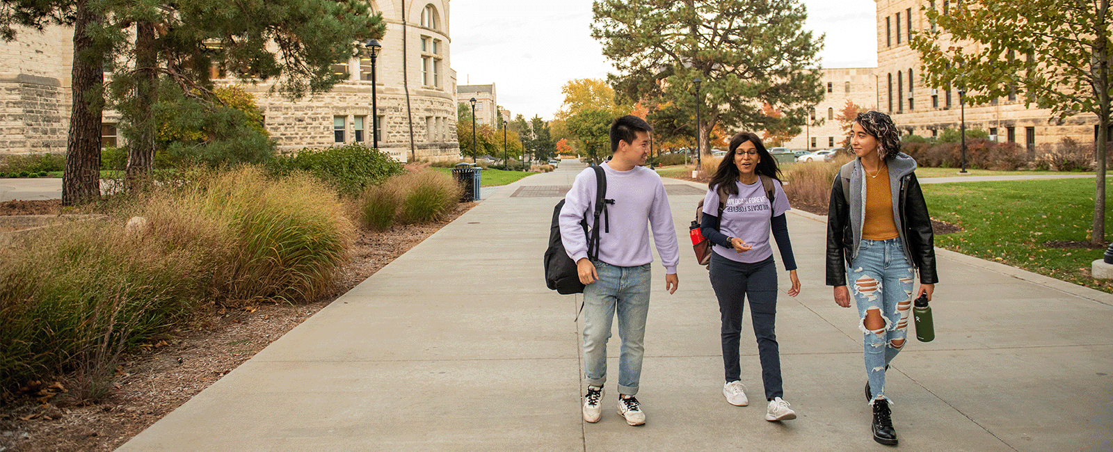 Students walk past Hale Library while talking to one another