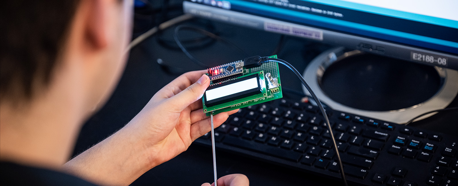 This image shows a person working on a circuit board. 