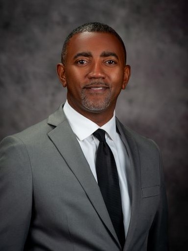 Eric Thompson headshot in grey suit