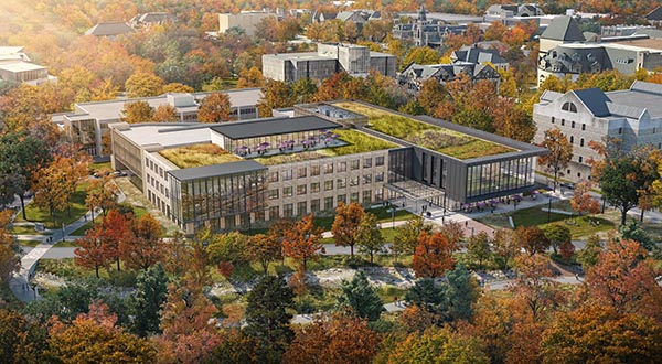 Aerial view of the proposed Integrated Wellness Building featuring a green roof space, surrounded by vibrant autumn trees.