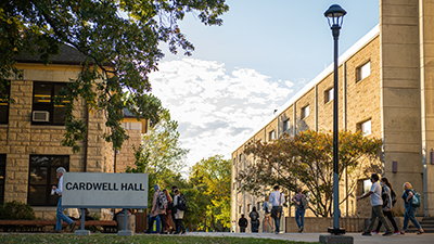 cardwell hall with students crossing in front of it after class