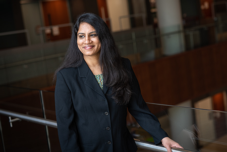 one with long dark hair in business attire looking off camera