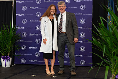 Dr. Derek Mosier presents a white coat to one of the veterinary students