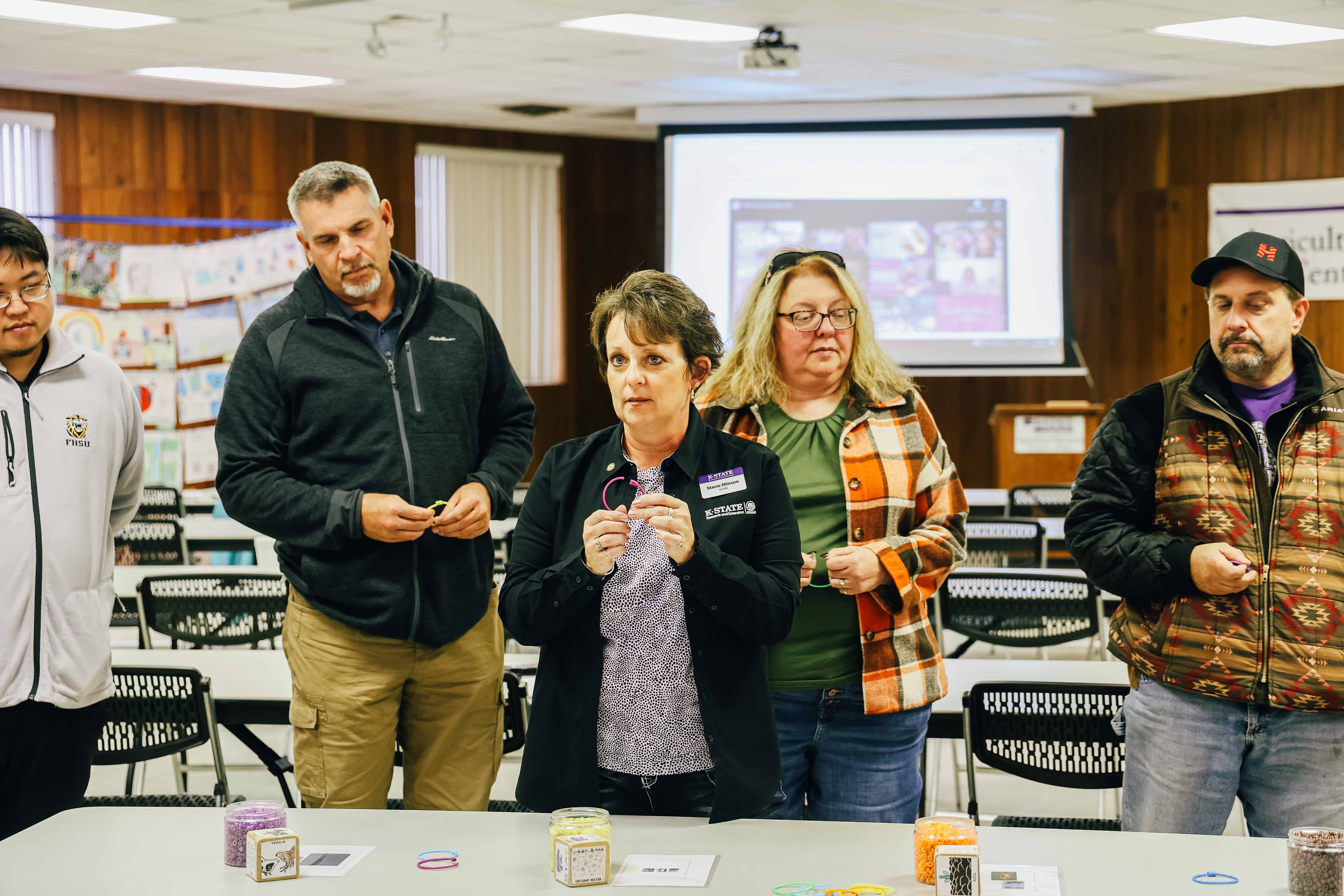 Stacie Edgett-Minson, K-State Research and Extension watershed specialist, center, highlights water resiliency during the Know Your Water event as part of the K-State community visit.