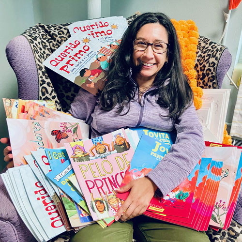 Claudia Nazario with children's books for bilingual story time at Manhattan Public Library