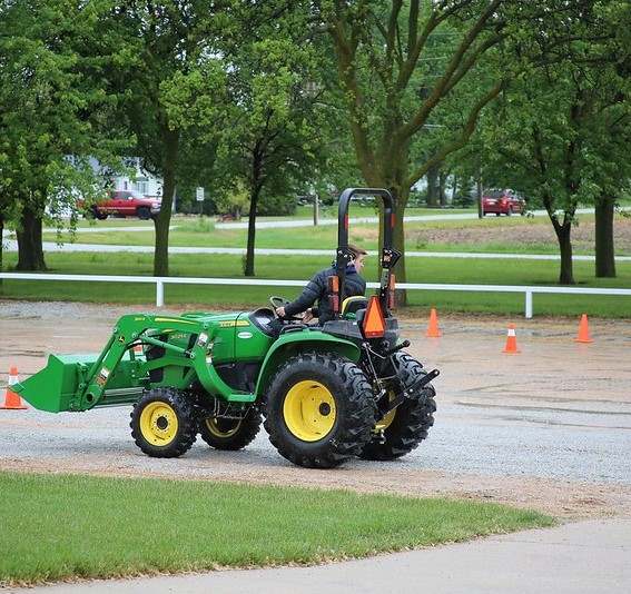 Young man on a green tractor.