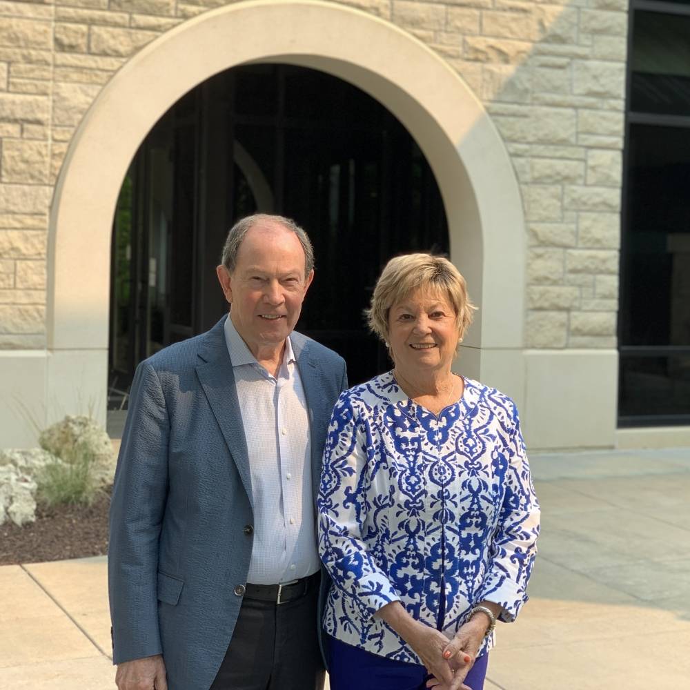 Mary Lynn and Warren Staley pose for a a photo in front of the Leadership Studies building