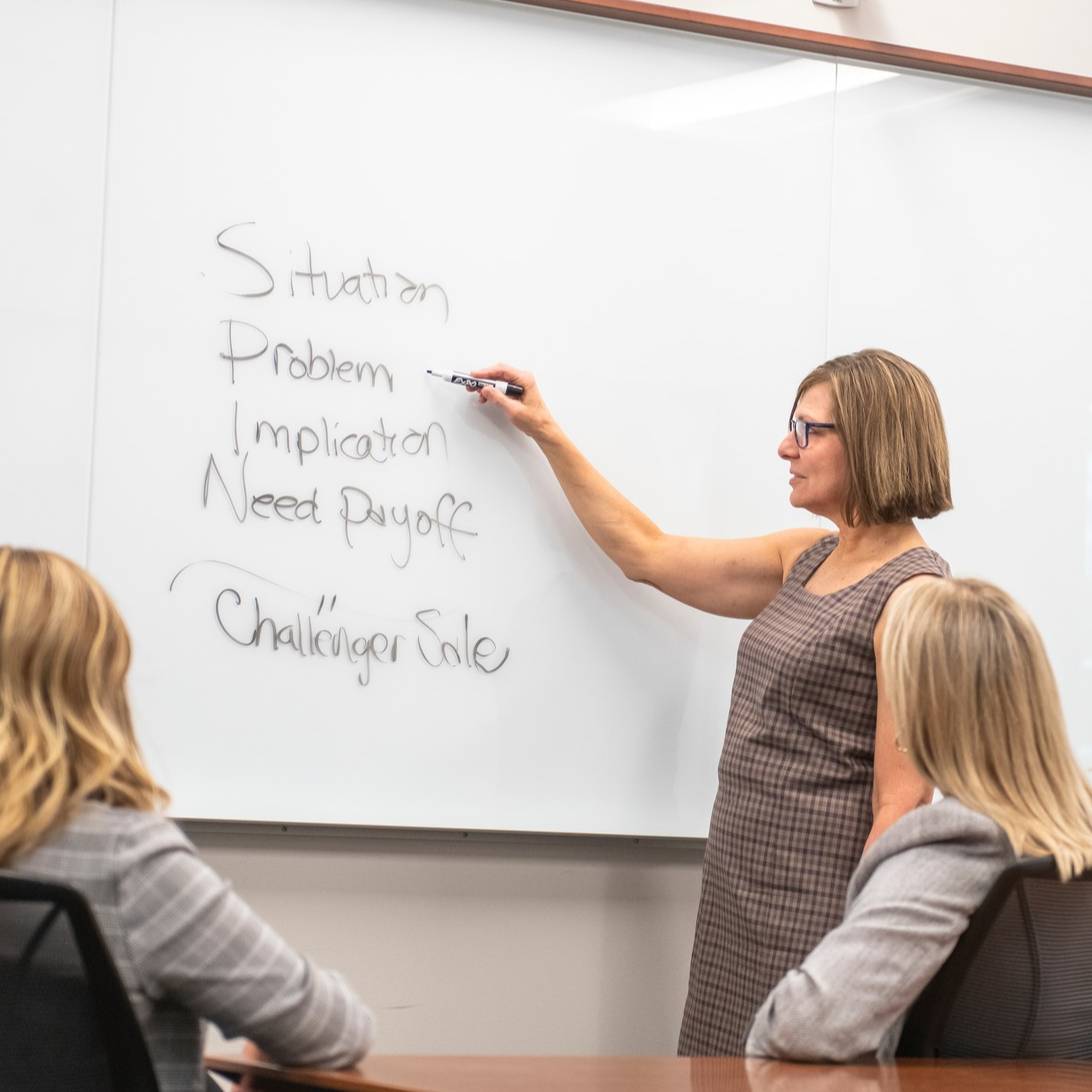 Woman writing on whiteboard