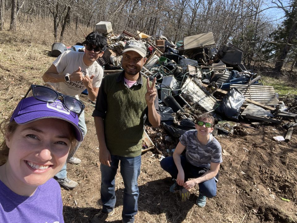 Students pose for a selfie in the middle of a community cleanup