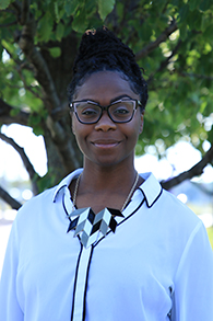 Portrait photo of Christal Cadenhead, a black woman wearing glasses and a white shirt