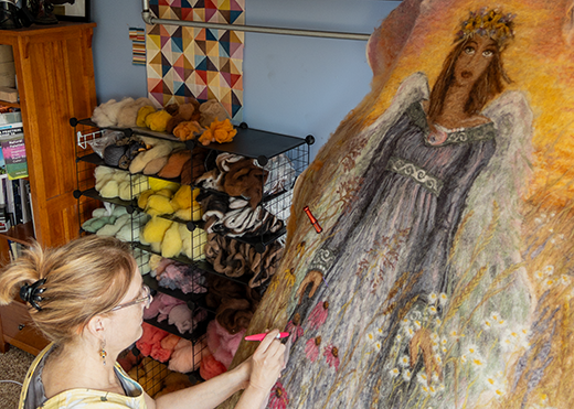 A woman works on felting a sustainable coffin cover