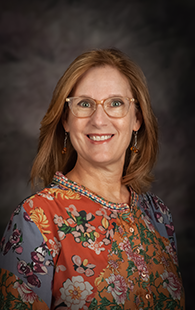 A portrait photo of a white woman with glasses