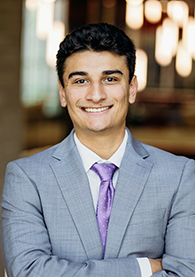 A student in a gray suit and purple tie.