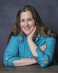 Jennifer Ifft sits and poses for a portrait, her chin resting in her hand.