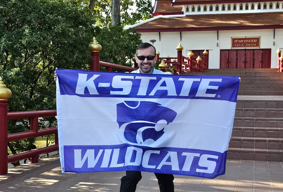 Danny Callahan poses with a K-State flag in Chiang Mai. 