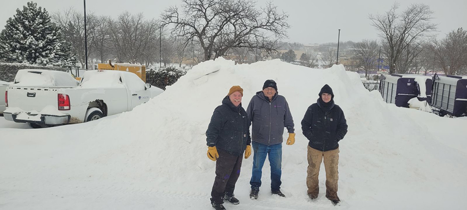 Bill Burris, Brian Sheets, Sydney Callaway - members of the K-State's landscape team — pose in front of a mound of snow they helped clear.