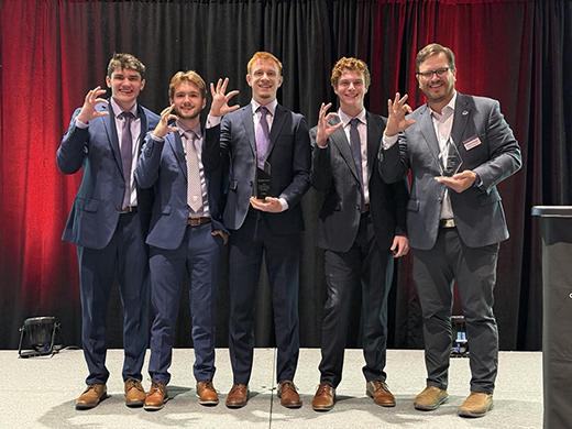 A group of students in suits giving the Wildcat hand symbol