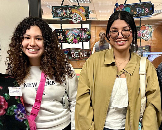 A pair of graduate students pose for a side-by-side portrait in the Manhattan Public Library.