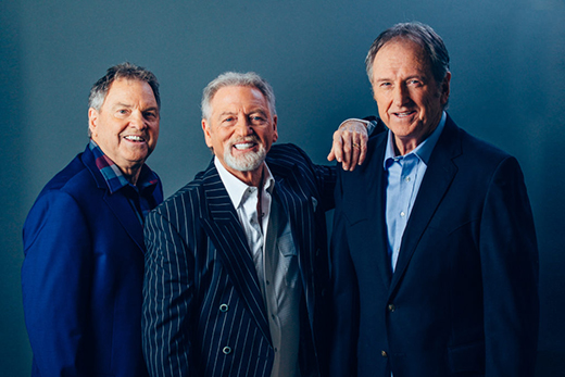 Three men in front of a blue background