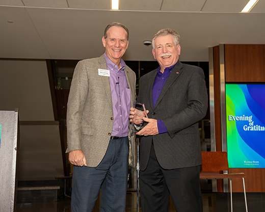 Two men standing with an award