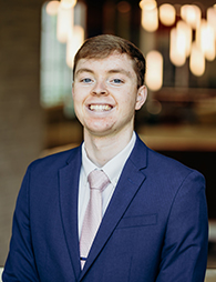 A young man in a blue blazer.