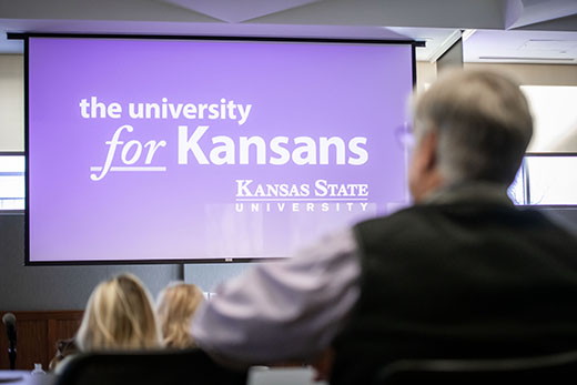 A room of people with a purple presentation