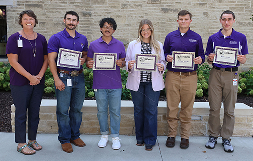 Caroline Rost, a dean of admissions for K-State's College of Veterinary Medicine, stands next to a row of five recipients of a scholarship for rural and underrepresented veterinary medicine students. The students are all holding up certificates.