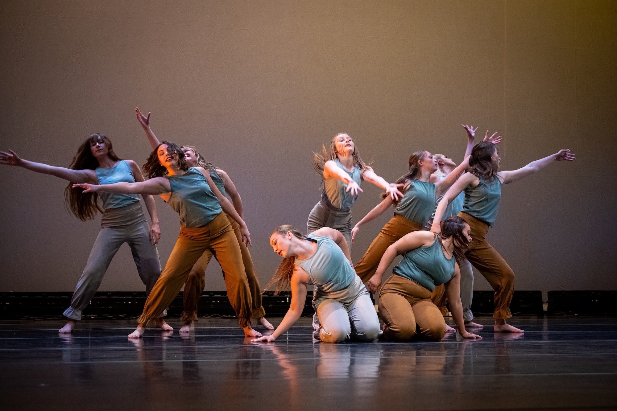 Dancers with hands raised on a black background