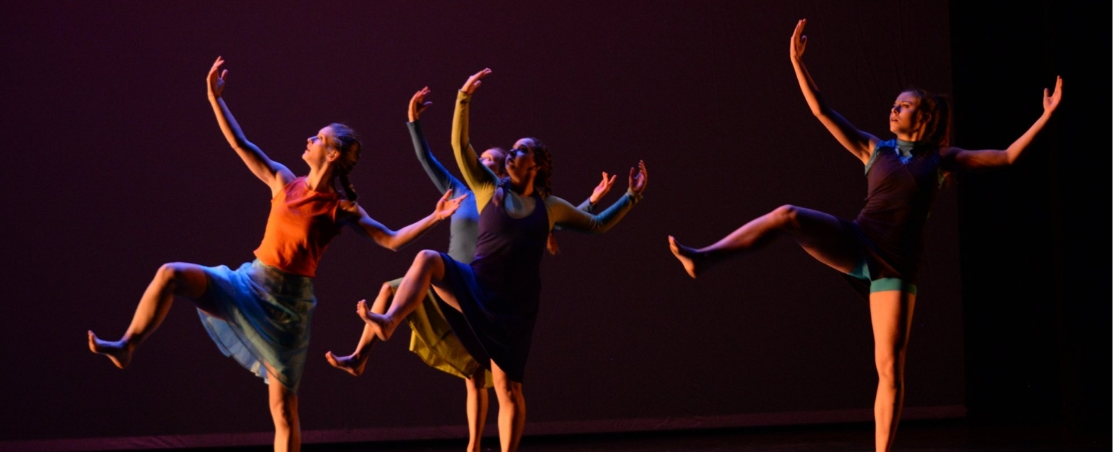 Dancers with hands raised on a black background