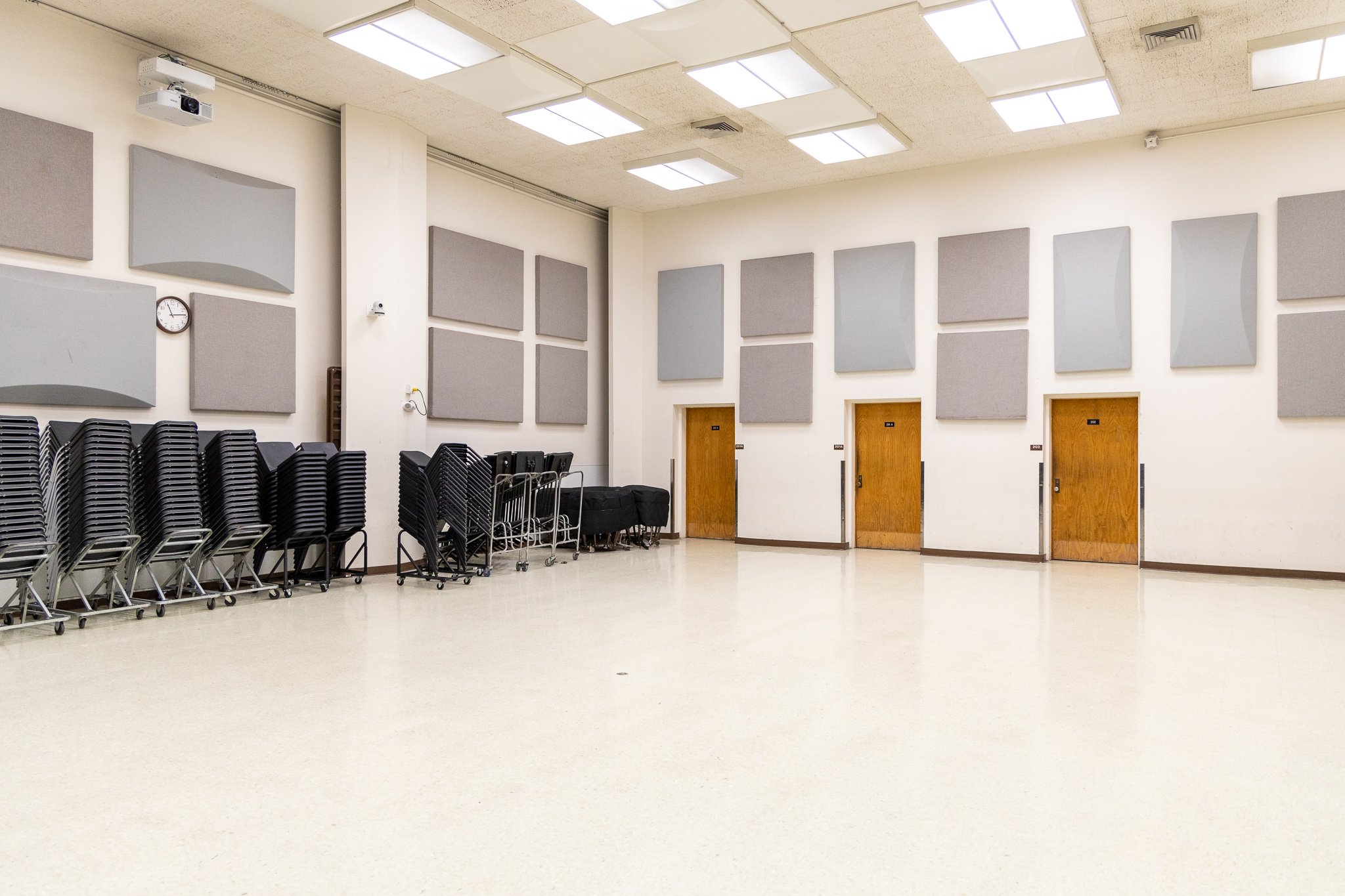 large room with chairs and cabinets along the wall