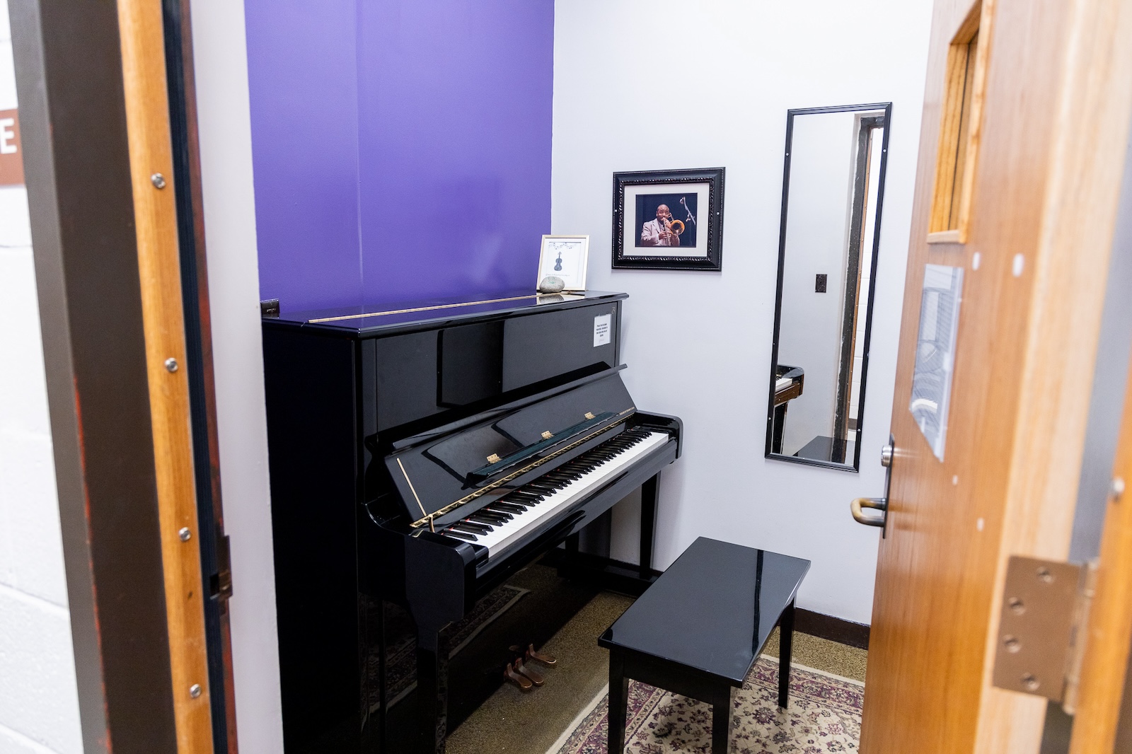 practice room with piano and purple wall