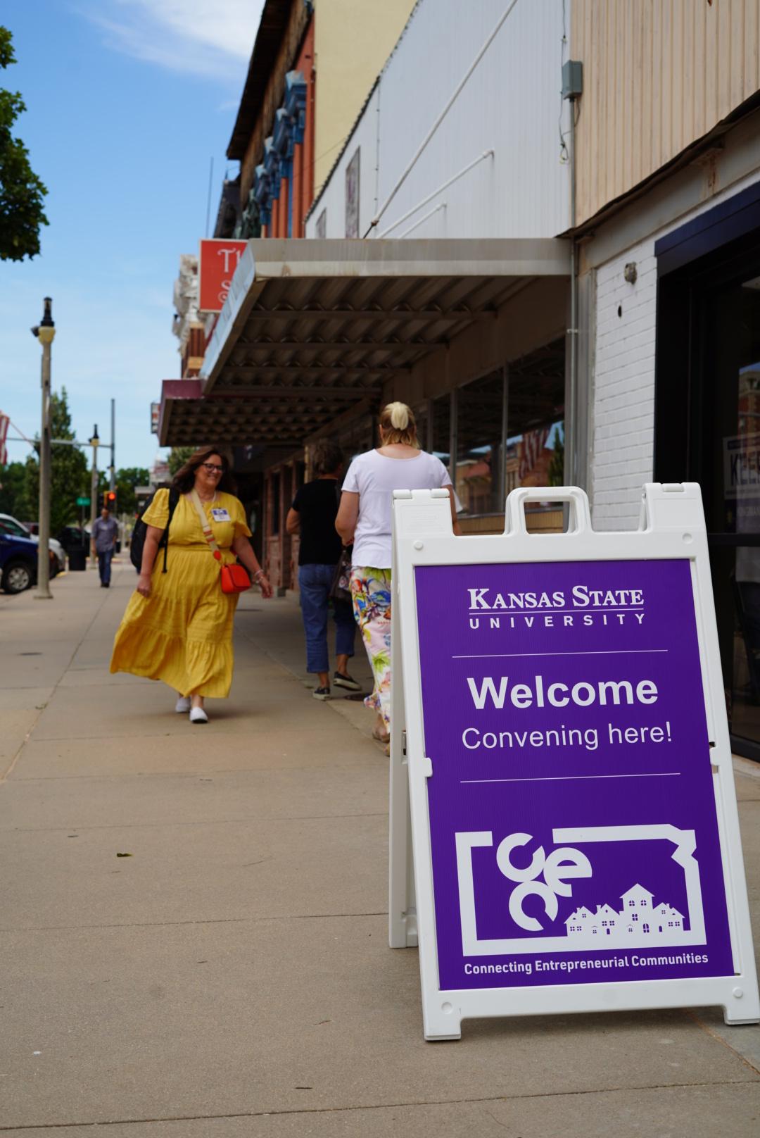 A purple sign with Kansas State University branding directing folks to the CEC convening.