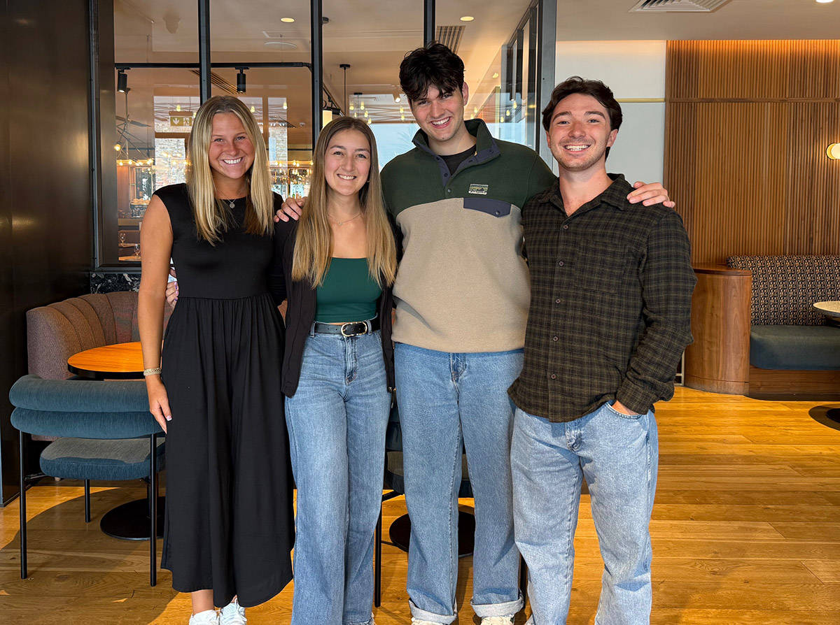 Four students, two male and two female, stand in a hotel in Ireland as they prepare for a business competition.
