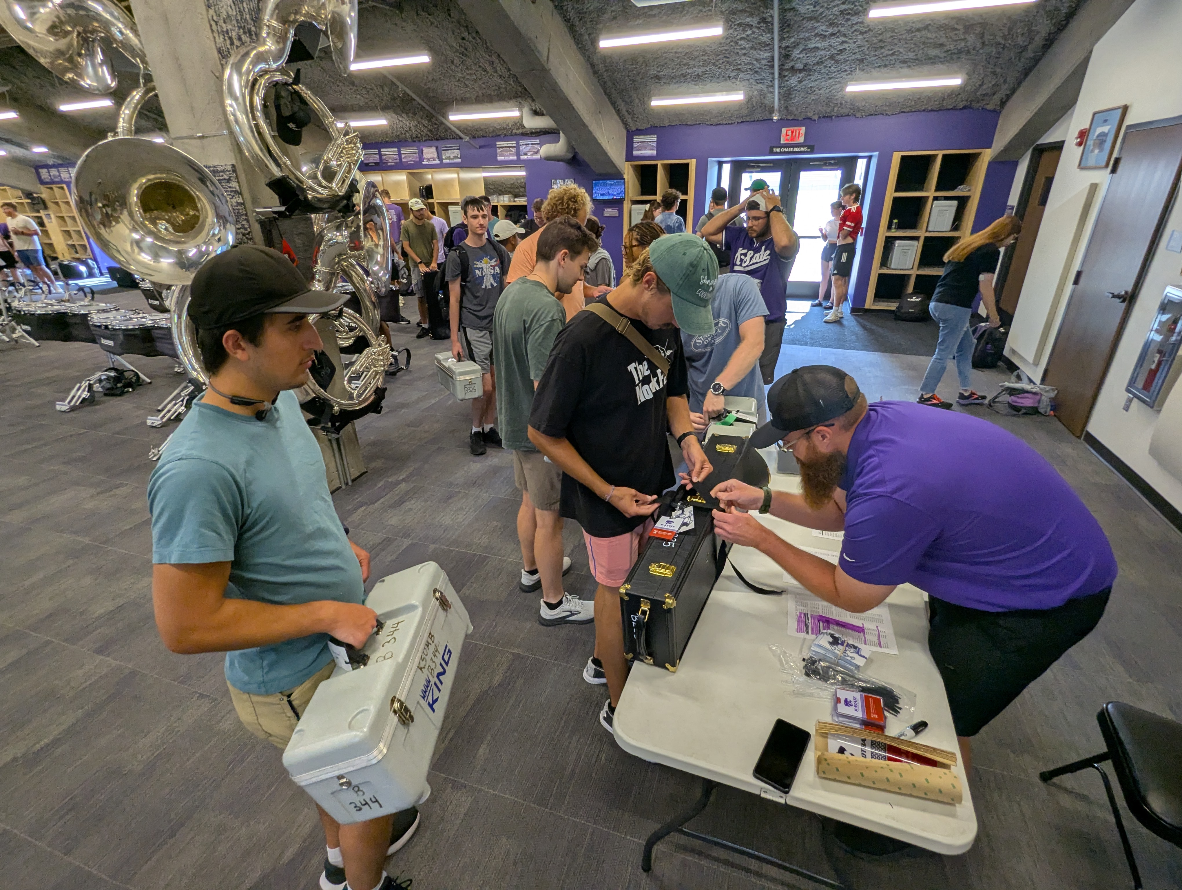 Instructor and instrument technician Josh Cook, right, checks and labels instruments as the K-State marching band prepares to ship items to Ireland.