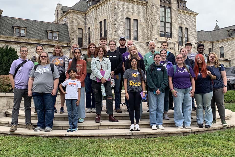 Matthew Kirk teaches Kickapoo children about geology using several rocks at a play table.