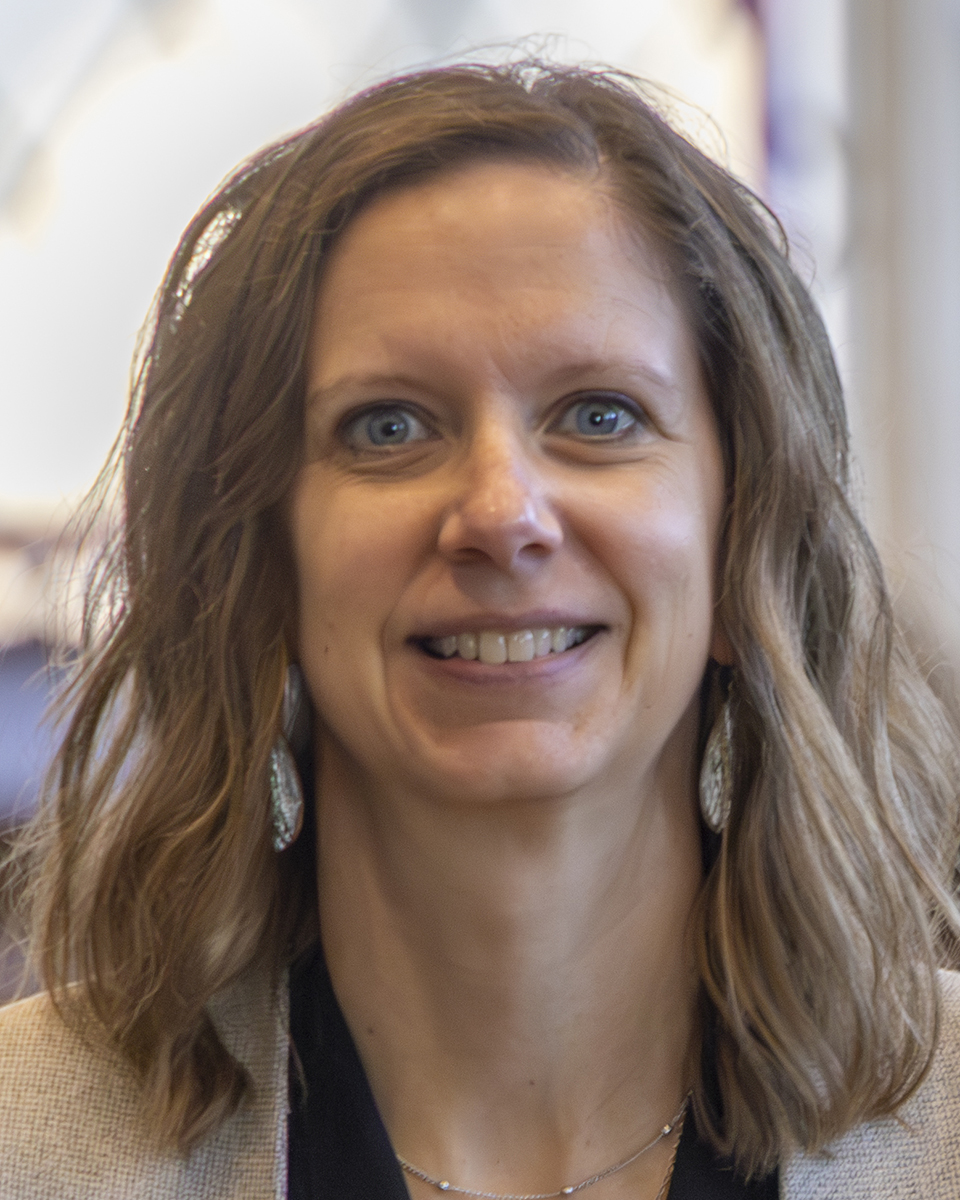 Jana Phelps smiles for a portrait in a library.