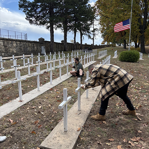 Students place American flags in a cemetary.