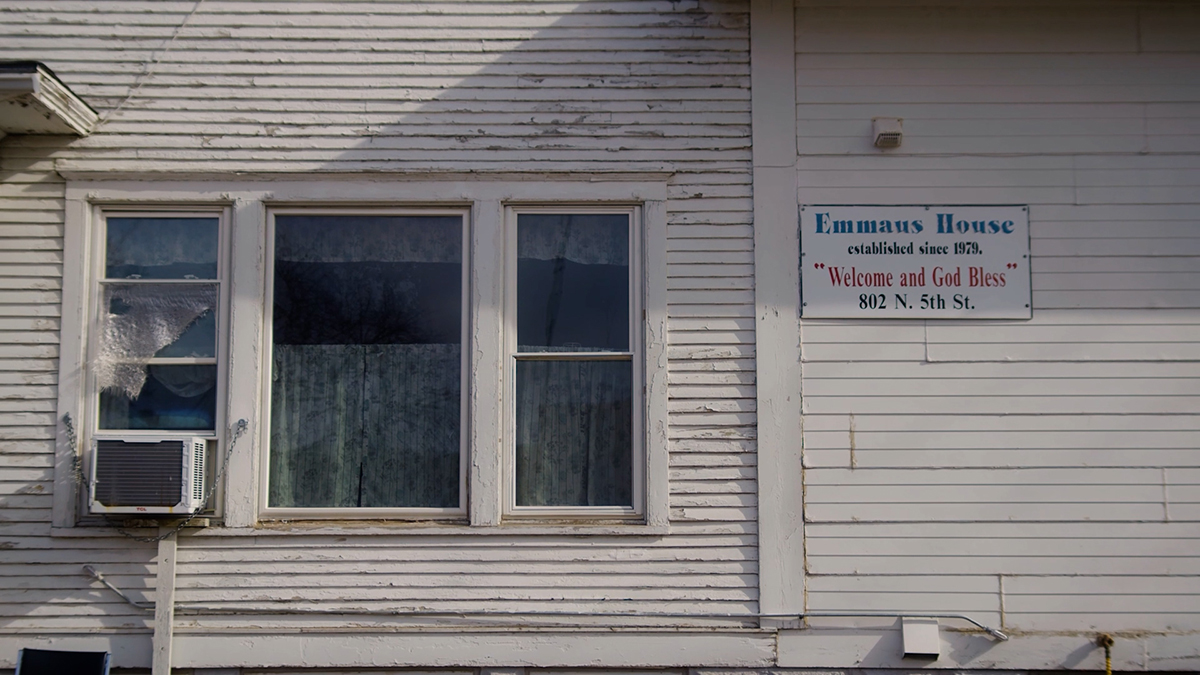 A white building with a sign saying "Emmaus House established since 1978 Welcome and God Bless 802 N. 5th St."