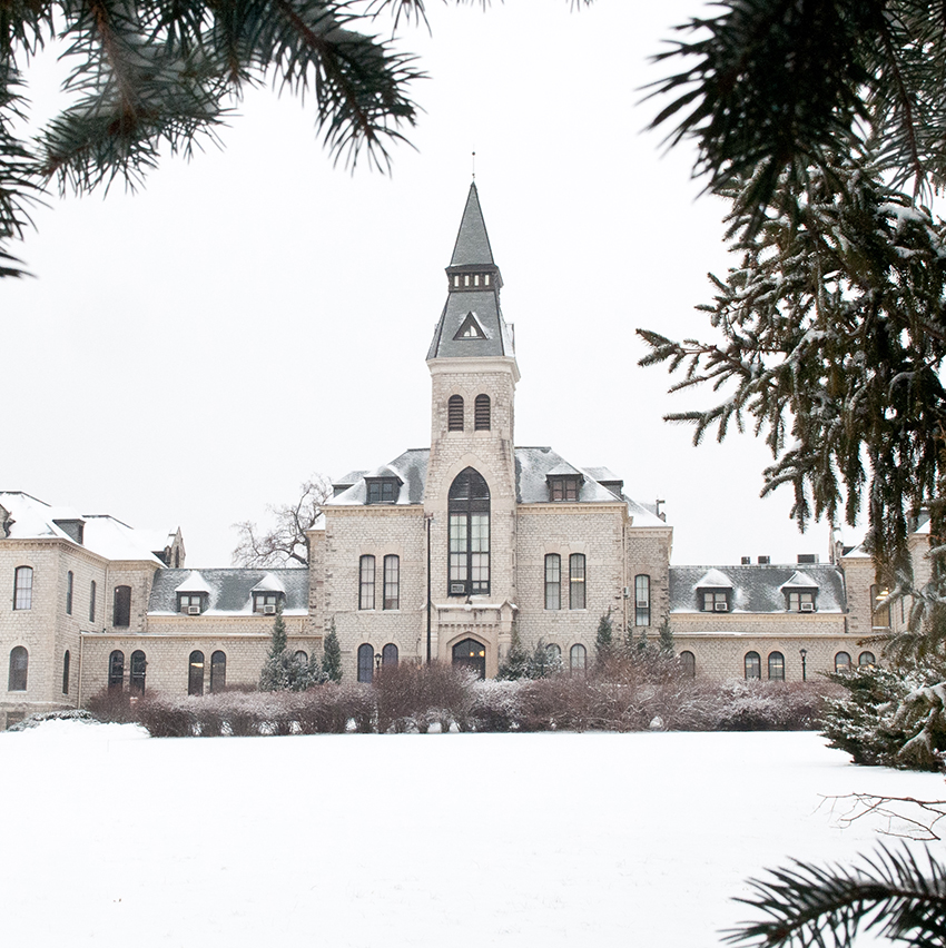 An exterior shot of Kansas State University's Anderson Hall shows its limestone tower under a blanket of snow.