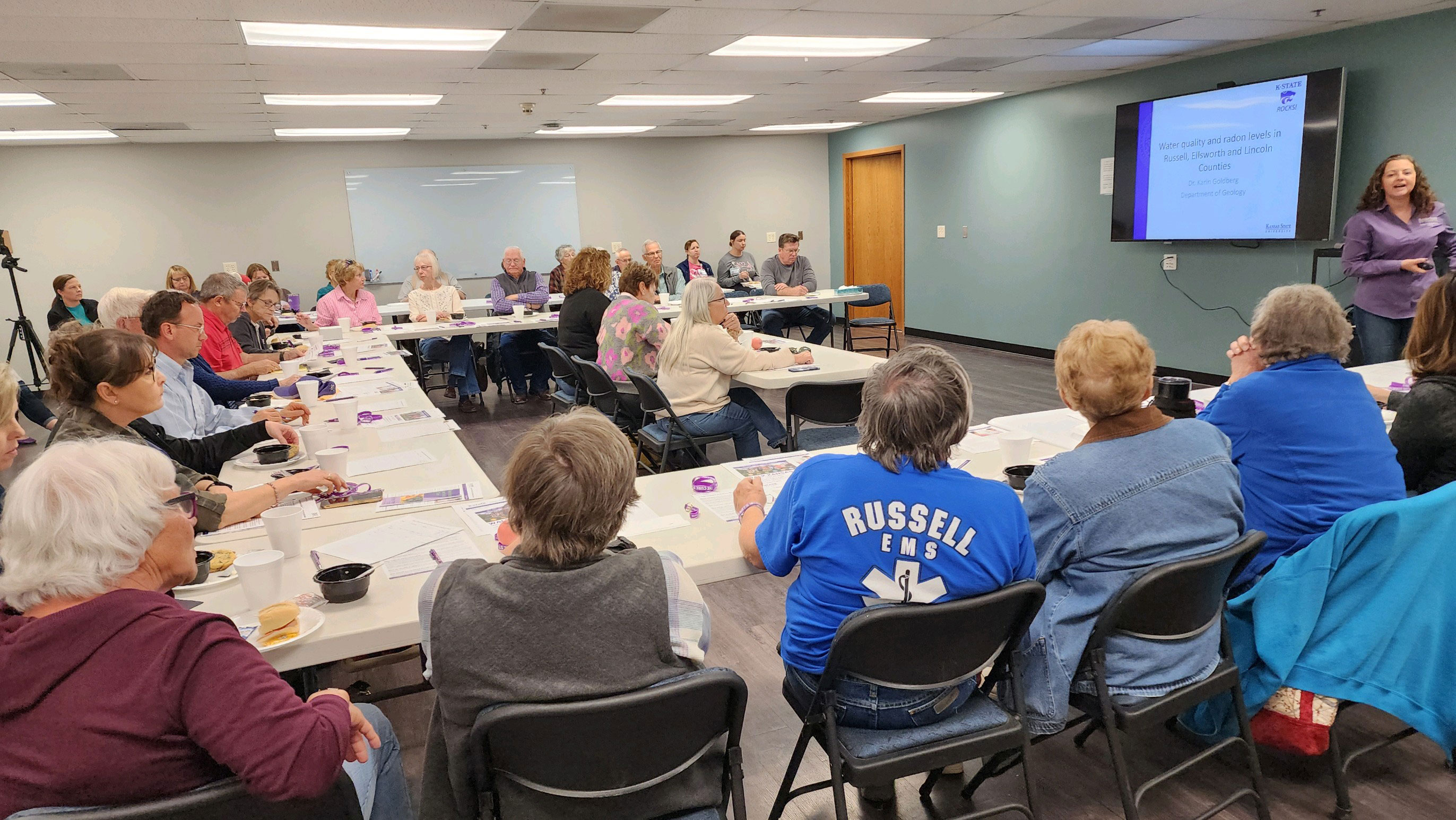 People sitting at tables listening to a presentation