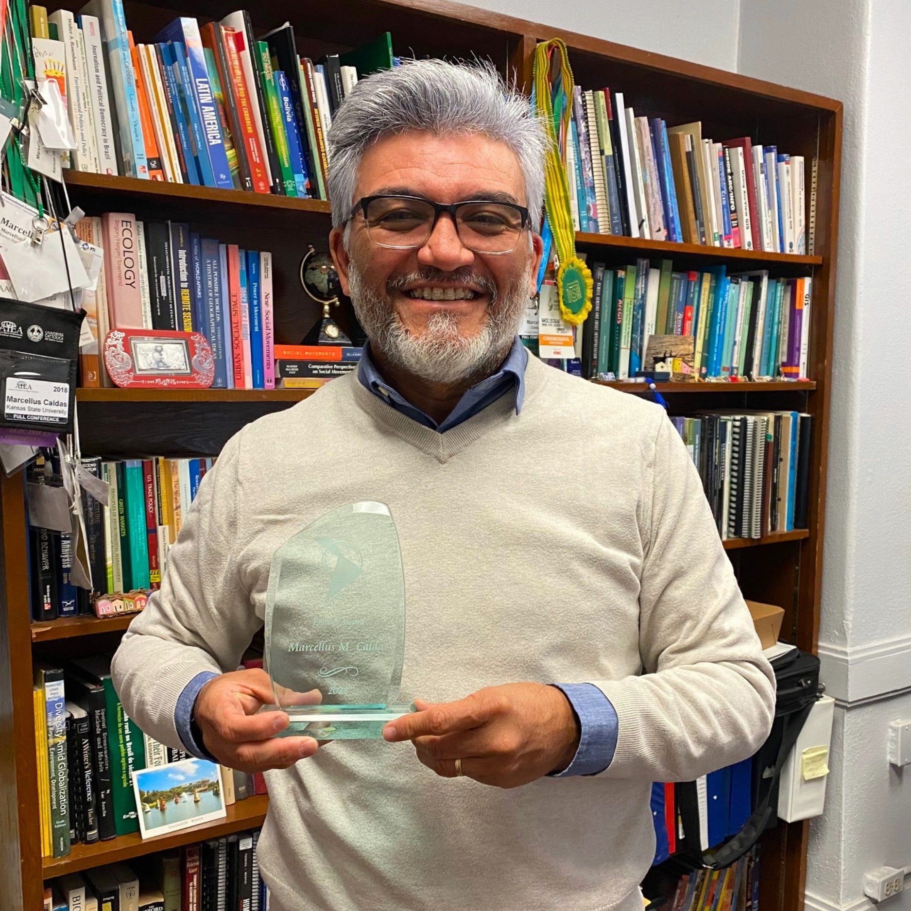 Marcellus Caldas holding his Enlaces award in 2022