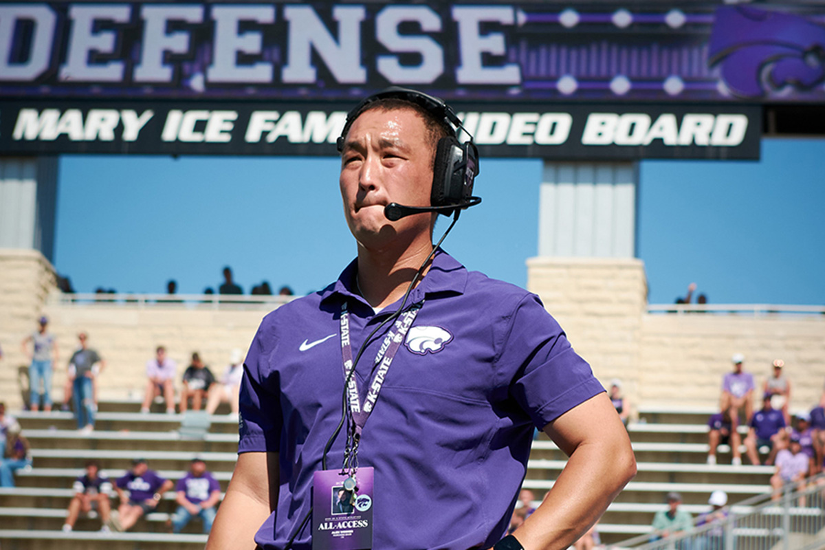 Alex Wimmer stands with the band at the K-State football stadium on a sunny day. 