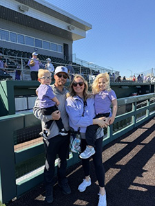 Amanda Burris stands with her family at a Kansas State University sporting event. 