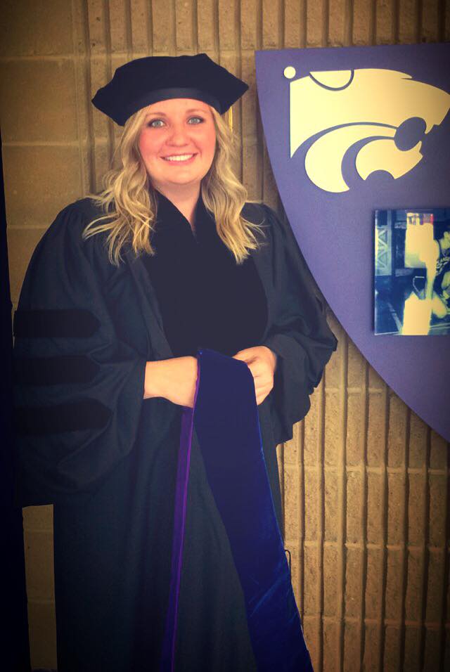 Amanda Burris standing in her college cap and gown. 