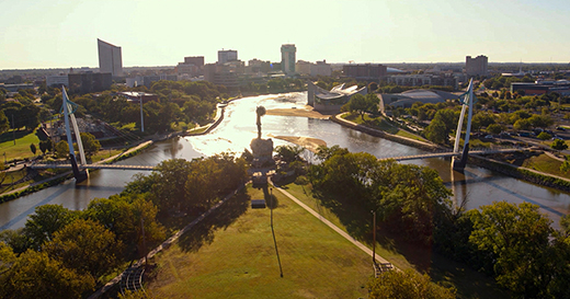 Sedgwick County regional community visit This image shows the Keeper of the Plains at the Arkansas River with the downtown Wichita skyline in the background.